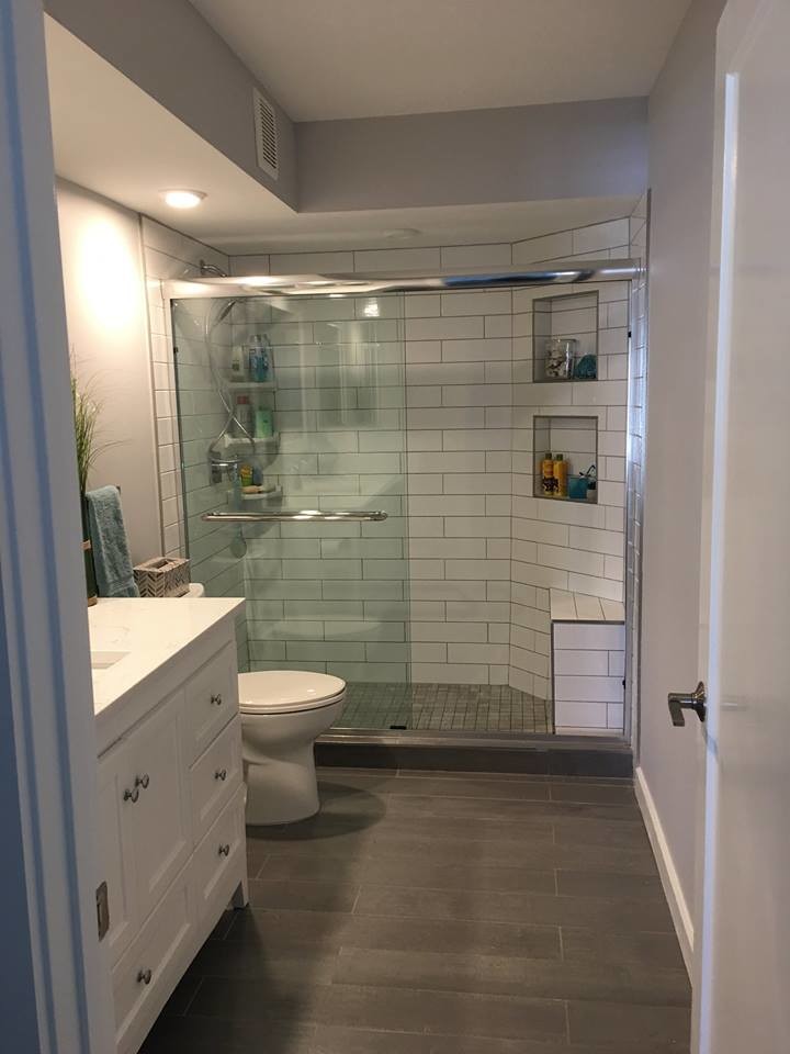 Bathroom - large coastal 3/4 white tile and stone tile dark wood floor bathroom idea in Tampa with raised-panel cabinets, white cabinets, a one-piece toilet, gray walls, a drop-in sink and solid surface countertops