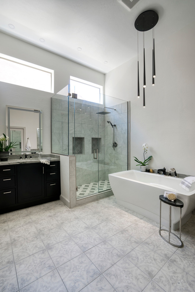 Photo of a large classic ensuite bathroom in Phoenix with shaker cabinets, black cabinets, a freestanding bath, a walk-in shower, grey tiles, porcelain tiles, white walls, porcelain flooring, a submerged sink, quartz worktops, multi-coloured floors, a hinged door, grey worktops, a shower bench, a single sink and a freestanding vanity unit.