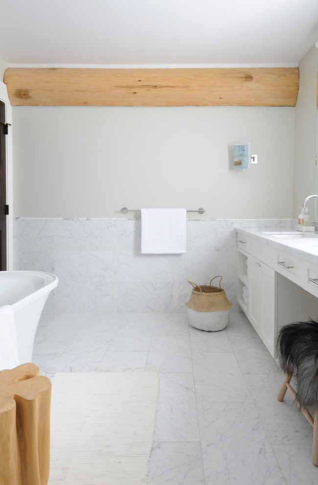 На фото: большая главная ванная комната в стиле неоклассика (современная классика) с фасадами в стиле шейкер, белыми фасадами, отдельно стоящей ванной, белой плиткой, мраморной плиткой, мраморным полом и мраморной столешницей