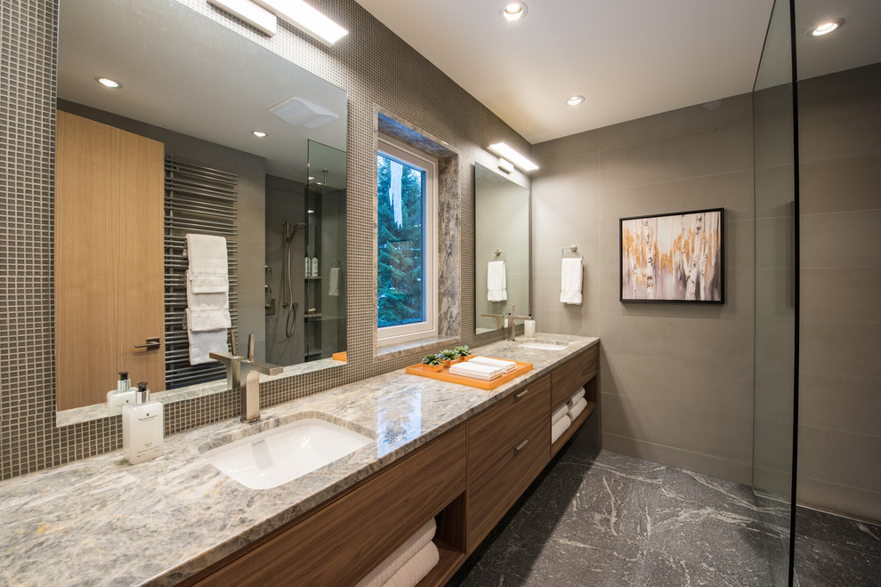 Inspiration pour une salle de bain principale minimaliste en bois brun de taille moyenne avec un placard à porte plane, une douche à l'italienne, WC suspendus, un carrelage gris, un carrelage de pierre, un mur gris, un lavabo encastré et un plan de toilette en quartz.