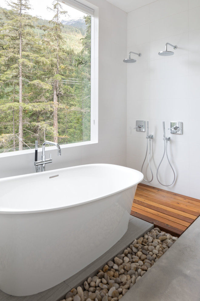 Пример оригинального дизайна: главная ванная комната в скандинавском стиле с отдельно стоящей ванной, двойным душем, белой плиткой и открытым душем