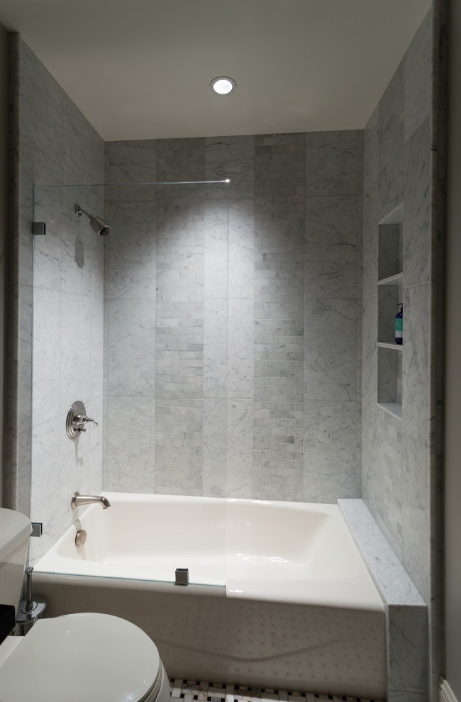 Exemple d'une salle d'eau chic de taille moyenne avec un combiné douche/baignoire, une baignoire indépendante, WC séparés, un placard à porte shaker, des portes de placard blanches, un carrelage gris, un carrelage métro, un mur beige, un sol en marbre, un lavabo encastré et un plan de toilette en granite.