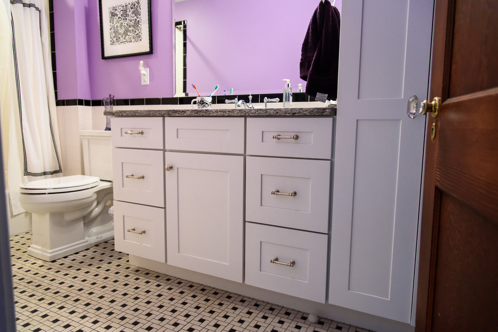 Idée de décoration pour une salle d'eau design de taille moyenne avec un placard à porte shaker, des portes de placard blanches, une baignoire en alcôve, un combiné douche/baignoire, WC séparés, un carrelage noir et blanc, des carreaux de céramique, un mur violet, un sol en carrelage de céramique, un lavabo encastré et un plan de toilette en granite.