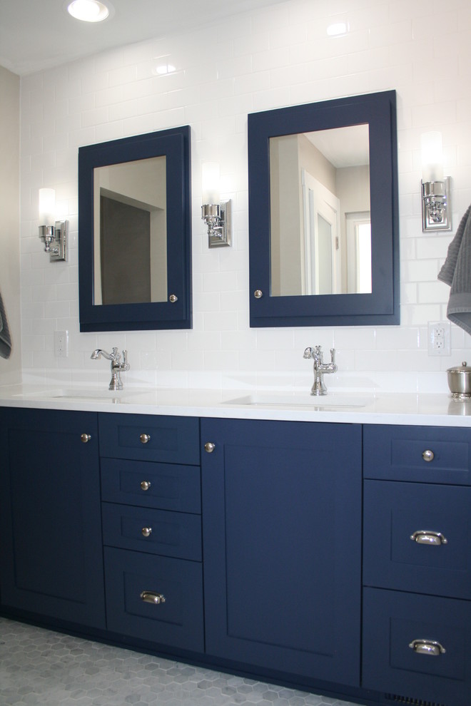 Klassisk inredning av ett badrum, med luckor med infälld panel, blå skåp, en dusch i en alkov, en toalettstol med separat cisternkåpa, vit kakel, keramikplattor, vita väggar, marmorgolv, ett undermonterad handfat, bänkskiva i kvarts, vitt golv och dusch med gångjärnsdörr