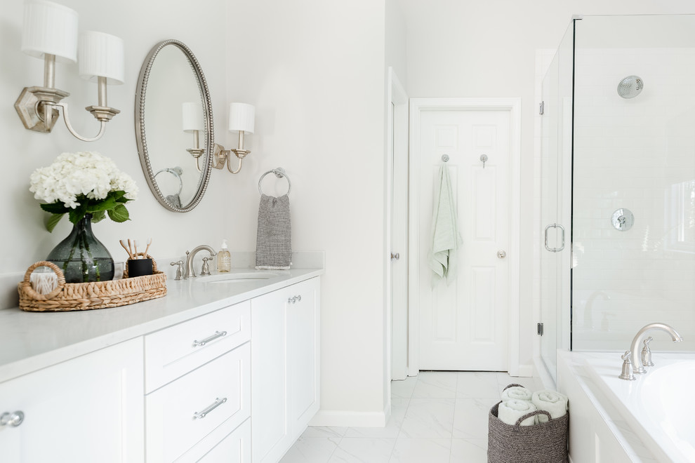 Idée de décoration pour une salle de bain tradition avec un placard à porte shaker, des portes de placard blanches, une baignoire posée, une douche d'angle, WC séparés, un carrelage blanc, des carreaux de céramique, un mur gris, un sol en carrelage de porcelaine, un lavabo encastré, un plan de toilette en quartz modifié, un sol blanc, une cabine de douche à porte battante et un plan de toilette blanc.