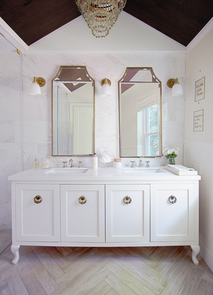Cette photo montre une salle de bain chic avec des portes de placard blanches, un carrelage gris, un carrelage blanc, du carrelage en marbre, un mur blanc, parquet clair, un lavabo encastré, un sol beige, un plan de toilette blanc et un placard à porte shaker.
