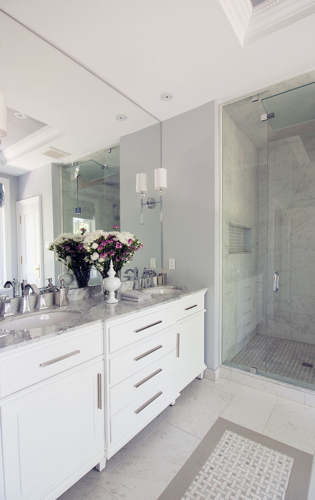 Design ideas for a medium sized traditional ensuite bathroom in Toronto with freestanding cabinets, white cabinets, a freestanding bath, an alcove shower, a one-piece toilet, white tiles, porcelain tiles, grey walls, porcelain flooring, a submerged sink and marble worktops.