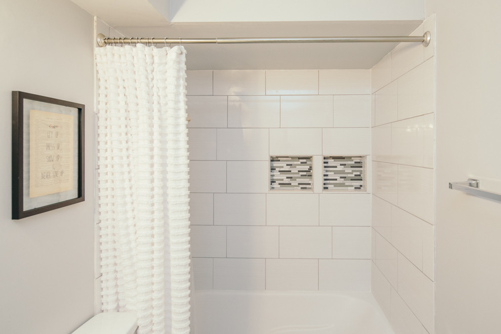 Medium sized contemporary shower room bathroom in Indianapolis with an alcove bath, a shower/bath combination, porcelain tiles, white walls, shaker cabinets, grey cabinets, a two-piece toilet, ceramic flooring, a submerged sink, solid surface worktops, white floors and a shower curtain.