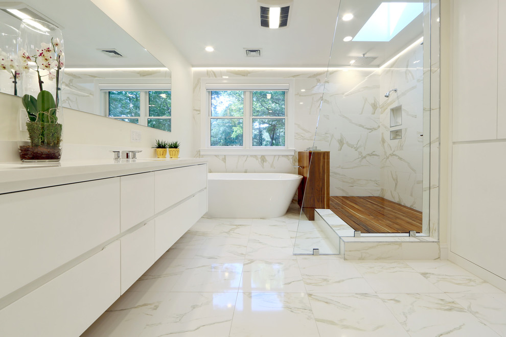 Exempel på ett modernt vit vitt en-suite badrum, med ett undermonterad handfat, släta luckor, vita skåp, bänkskiva i akrylsten, ett fristående badkar, en öppen dusch, vit kakel, vita väggar, marmorgolv, med dusch som är öppen och marmorkakel