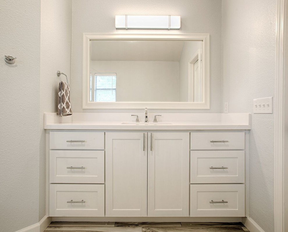 Ejemplo de cuarto de baño principal tradicional de tamaño medio con armarios estilo shaker, puertas de armario blancas, ducha empotrada, baldosas y/o azulejos grises, paredes blancas, lavabo bajoencimera y encimera de cuarzo compacto