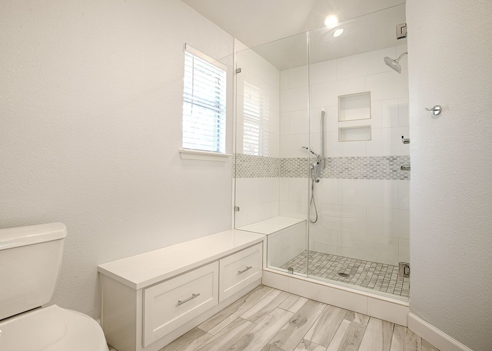 Imagen de cuarto de baño principal clásico de tamaño medio con armarios estilo shaker, puertas de armario blancas, ducha empotrada, baldosas y/o azulejos grises, paredes blancas, lavabo bajoencimera y encimera de cuarzo compacto