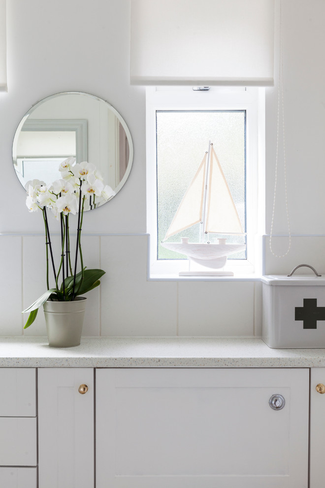 Свежая идея для дизайна: маленькая детская ванная комната в морском стиле с фасадами с утопленной филенкой, белыми фасадами, угловым душем, унитазом-моноблоком, белой плиткой, керамической плиткой, белыми стенами, полом из линолеума, накладной раковиной и столешницей из ламината для на участке и в саду - отличное фото интерьера