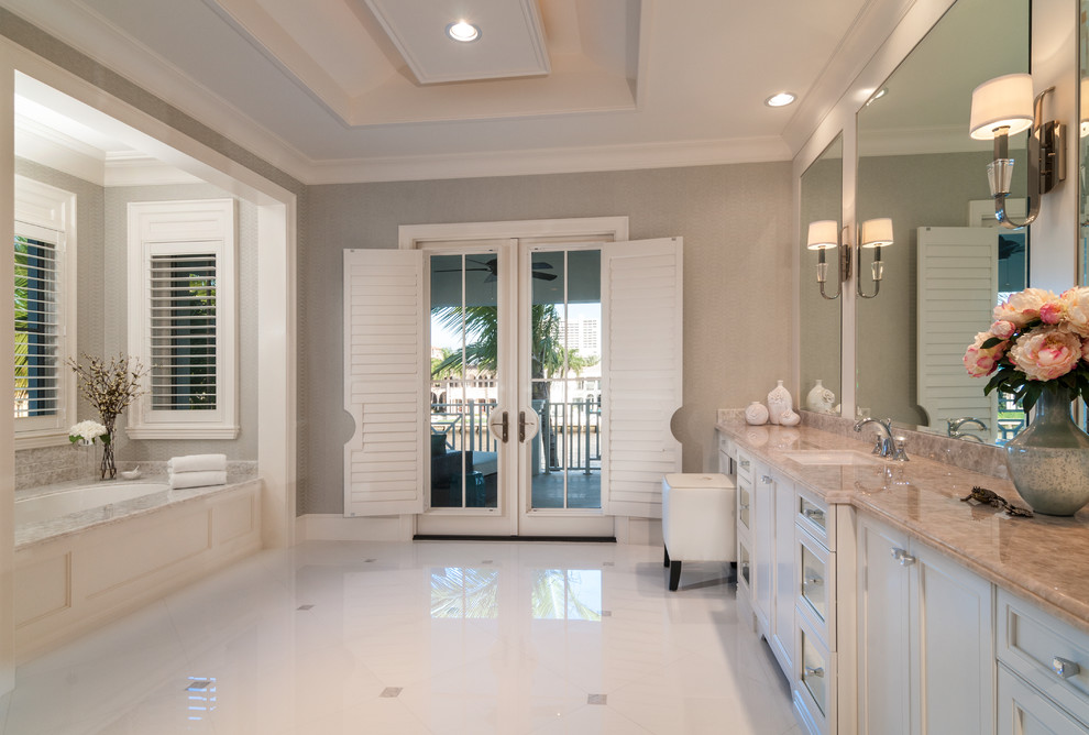 Modelo de cuarto de baño principal contemporáneo con encimera de mármol, bañera esquinera, baldosas y/o azulejos blancos, baldosas y/o azulejos de vidrio y paredes beige