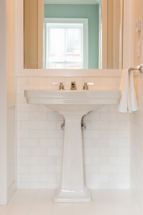 Imagen de cuarto de baño clásico con lavabo con pedestal, baldosas y/o azulejos blancos, baldosas y/o azulejos de piedra, paredes blancas y suelo de mármol