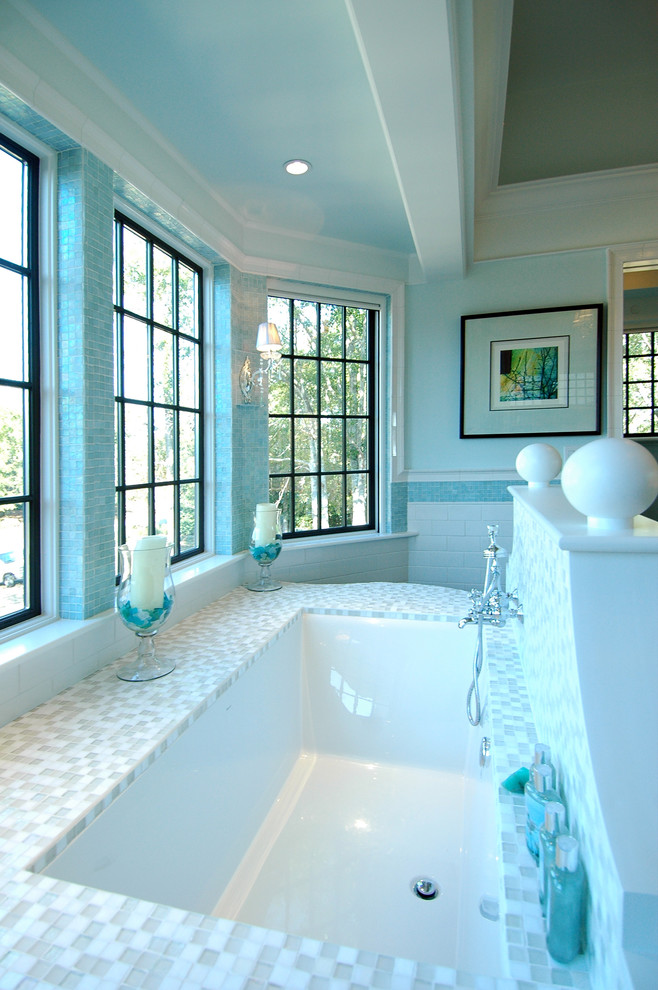 Idées déco pour une salle de bain principale bord de mer de taille moyenne avec une baignoire encastrée, un carrelage beige, un carrelage blanc, mosaïque et un mur bleu.