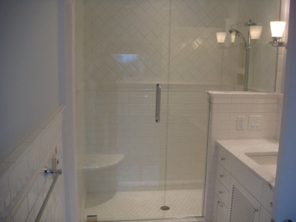 Modelo de cuarto de baño marinero con armarios con paneles lisos, puertas de armario blancas, ducha empotrada, paredes blancas, lavabo bajoencimera y encimera de mármol