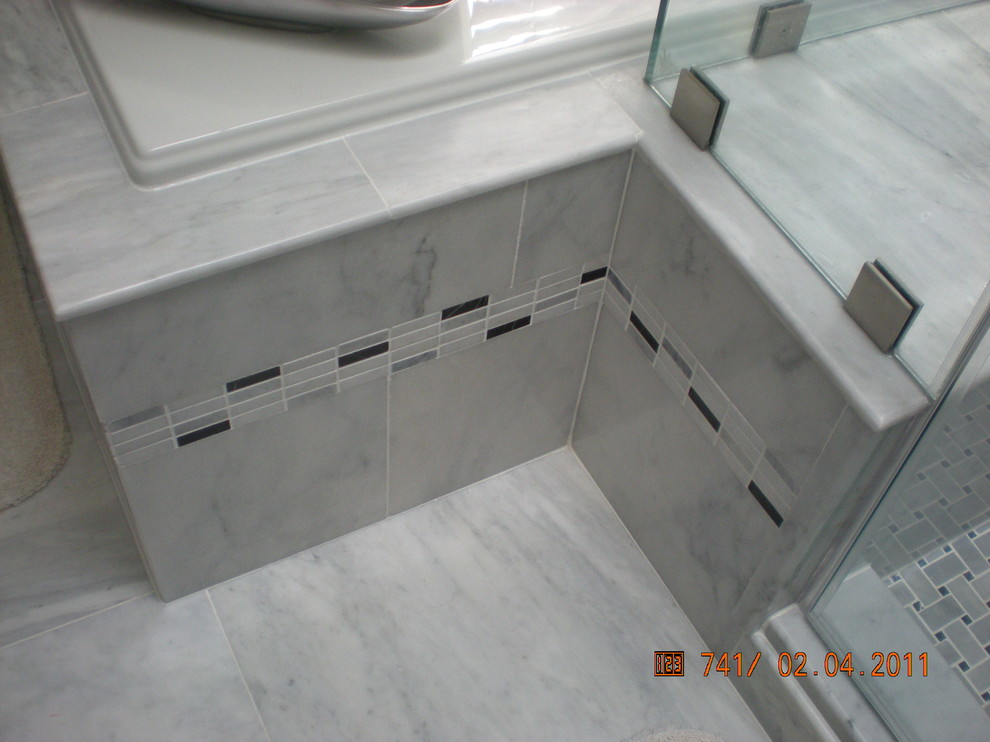 Пример оригинального дизайна: ванная комната в современном стиле с темными деревянными фасадами, мраморной столешницей и серой плиткой