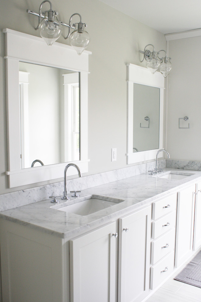 Modelo de cuarto de baño principal tradicional renovado con armarios estilo shaker, puertas de armario blancas y encimera de mármol