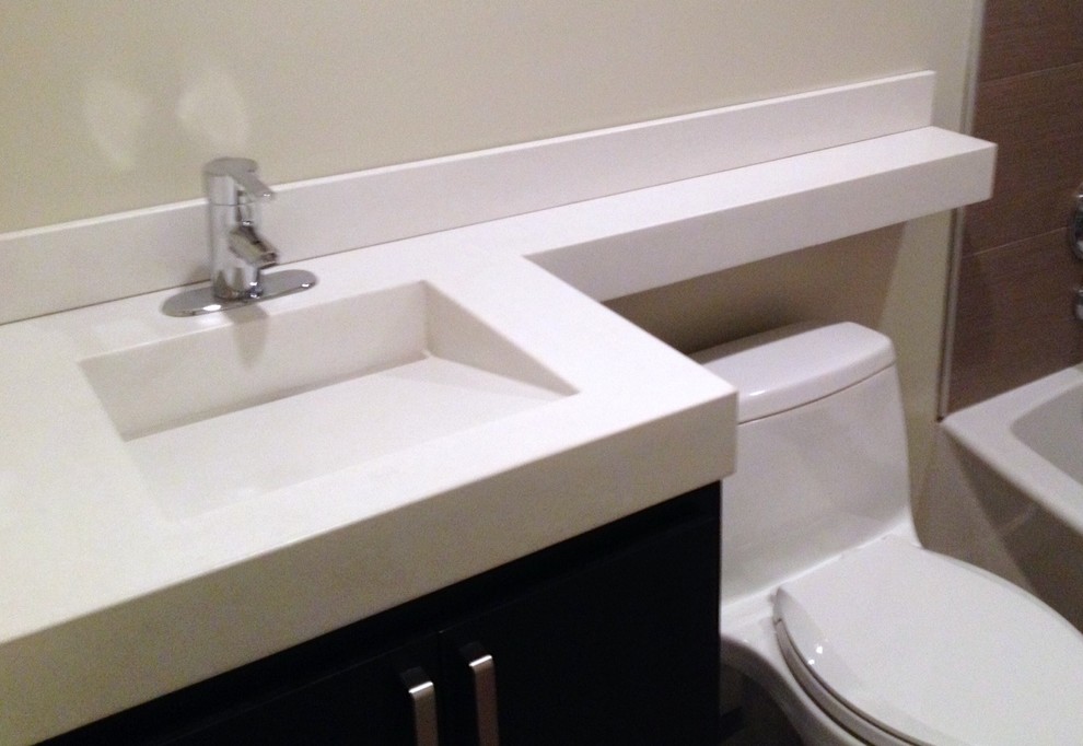 Ispirazione per una stanza da bagno minimal di medie dimensioni con lavabo integrato e top in cemento