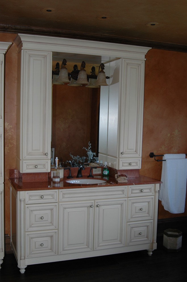 Großes Klassisches Badezimmer En Suite mit profilierten Schrankfronten, weißen Schränken, oranger Wandfarbe, dunklem Holzboden, Unterbauwaschbecken, Onyx-Waschbecken/Waschtisch, braunem Boden und roter Waschtischplatte in Sonstige