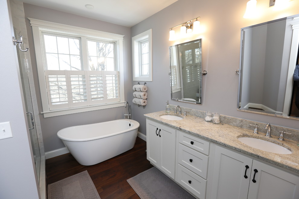 Bathroom - mid-sized craftsman master white tile and subway tile dark wood floor bathroom idea in Cedar Rapids with shaker cabinets, white cabinets, a one-piece toilet, blue walls, an undermount sink and granite countertops