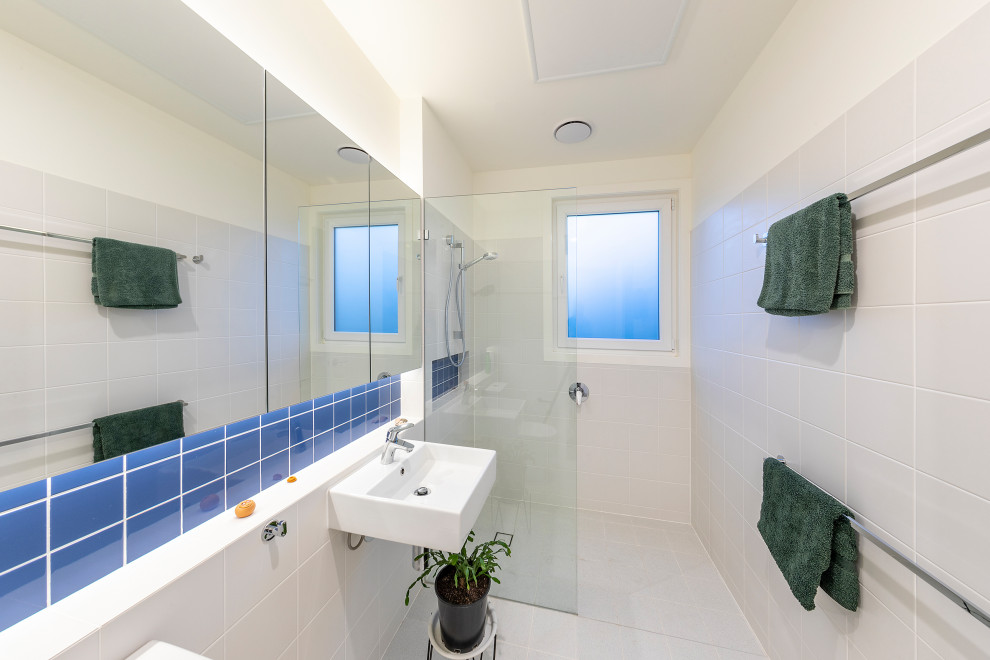 Inspiration för små moderna badrum för barn, med en öppen dusch, en toalettstol med hel cisternkåpa, vit kakel, keramikplattor, vita väggar, klinkergolv i keramik, ett väggmonterat handfat, vitt golv och med dusch som är öppen