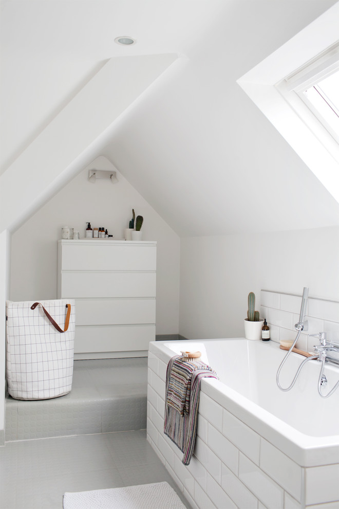 Imagen de cuarto de baño principal contemporáneo de tamaño medio con bañera encastrada, baldosas y/o azulejos blancos, baldosas y/o azulejos de cemento, paredes blancas y suelo gris