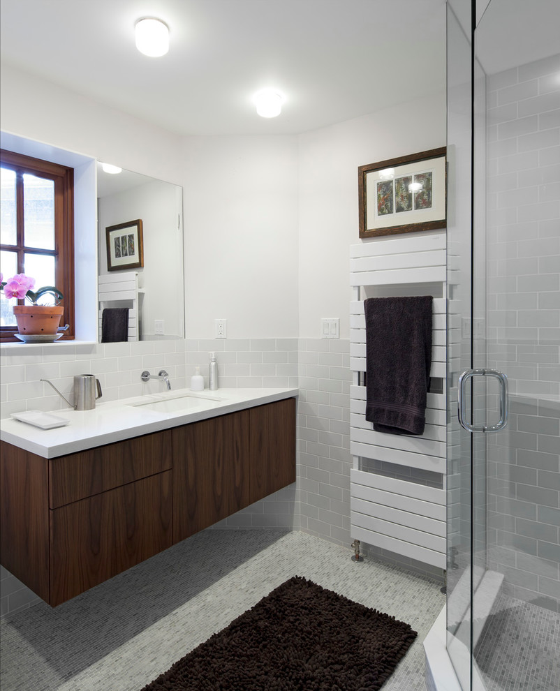 Inspiration for a medium sized contemporary ensuite bathroom in Toronto with flat-panel cabinets, dark wood cabinets, a freestanding bath, a shower/bath combination, a two-piece toilet, grey tiles, mosaic tiles, grey walls, marble flooring, a built-in sink and engineered stone worktops.