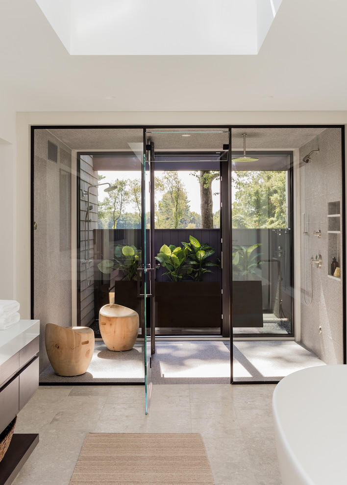 Стильный дизайн: ванная комната в современном стиле с плоскими фасадами, темными деревянными фасадами, отдельно стоящей ванной, серой плиткой, плиткой мозаикой, белыми стенами, бежевым полом и белой столешницей - последний тренд