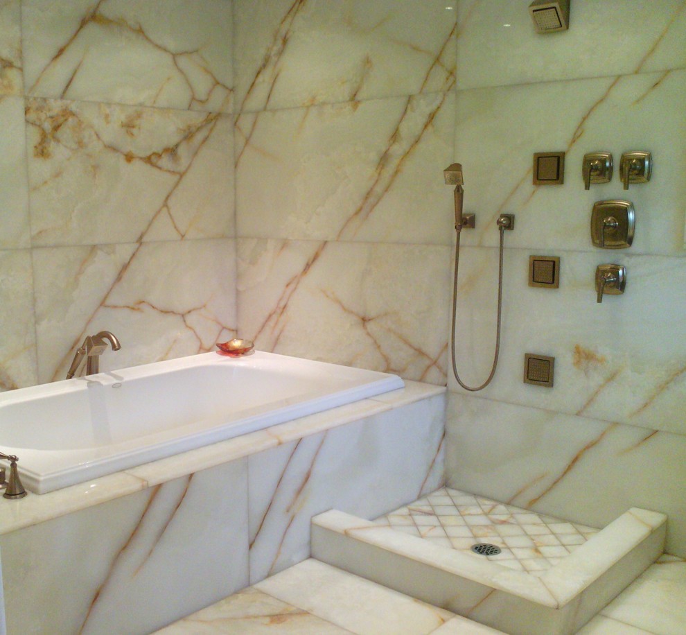 Immagine di una stanza da bagno minimalista con lavabo sottopiano, ante a filo, ante in legno scuro, top in onice, vasca ad alcova, doccia aperta, WC monopezzo, piastrelle bianche e lastra di pietra