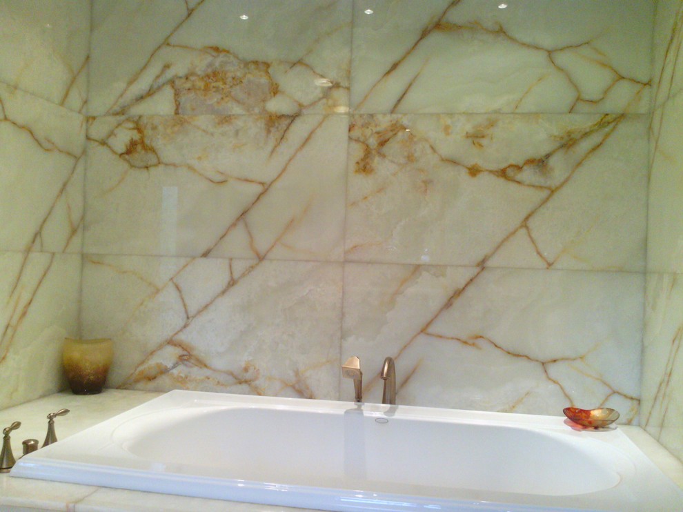 Exempel på ett modernt badrum, med ett undermonterad handfat, luckor med profilerade fronter, skåp i mellenmörkt trä, bänkskiva i onyx, ett badkar i en alkov, en öppen dusch, en toalettstol med hel cisternkåpa, vit kakel och stenhäll