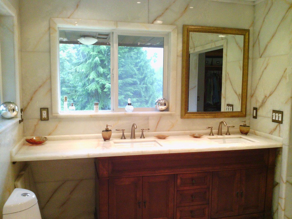 Bathroom - modern white tile bathroom idea in Seattle with an undermount sink, beaded inset cabinets, medium tone wood cabinets, onyx countertops and a one-piece toilet