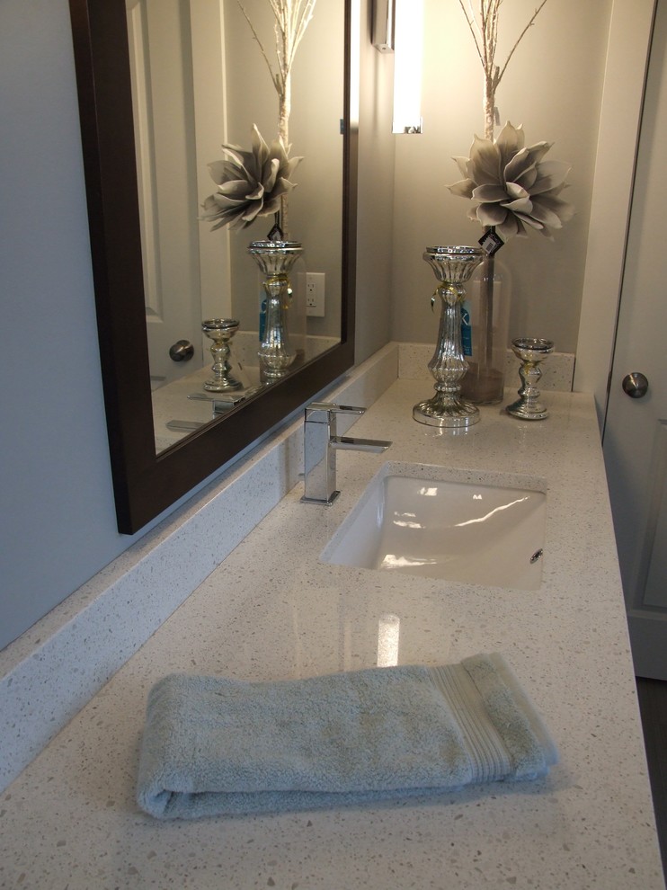 Ejemplo de cuarto de baño principal actual grande con armarios con paneles lisos, puertas de armario de madera en tonos medios, paredes grises, lavabo bajoencimera y encimera de granito