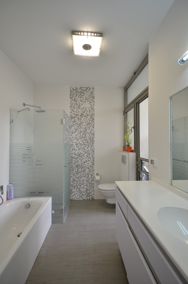 Idée de décoration pour une salle de bain design avec une baignoire indépendante et un plan de toilette blanc.