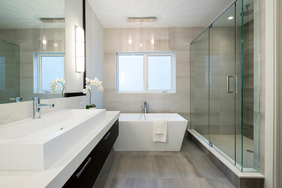 Идея дизайна: главная ванная комната среднего размера в современном стиле с отдельно стоящей ванной, открытым душем, серой плиткой, каменной плиткой, белыми стенами, полом из сланца, раковиной с несколькими смесителями и мраморной столешницей