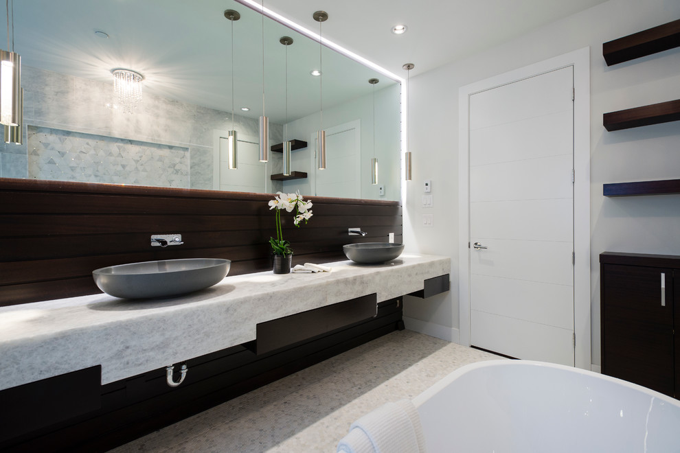 На фото: главная ванная комната среднего размера в современном стиле с отдельно стоящей ванной, разноцветной плиткой, галечной плиткой, полом из мозаичной плитки и мраморной столешницей