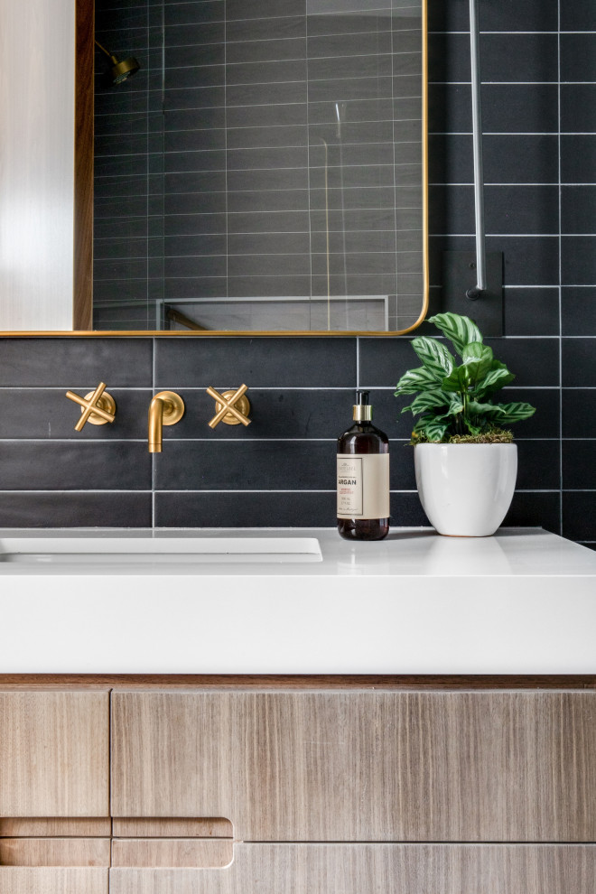 На фото: ванная комната в стиле ретро с светлыми деревянными фасадами, черной плиткой и белой столешницей с