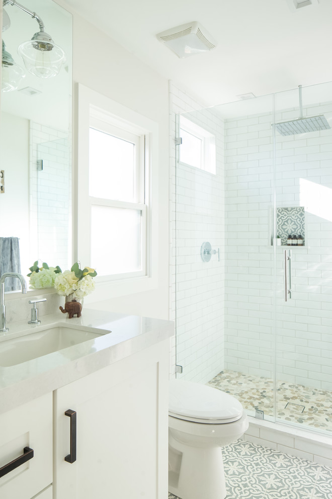 Small transitional 3/4 white tile and ceramic tile linoleum floor and turquoise floor alcove shower photo in Orange County with shaker cabinets, white cabinets, solid surface countertops, a two-piece toilet, white walls, an undermount sink and a hinged shower door