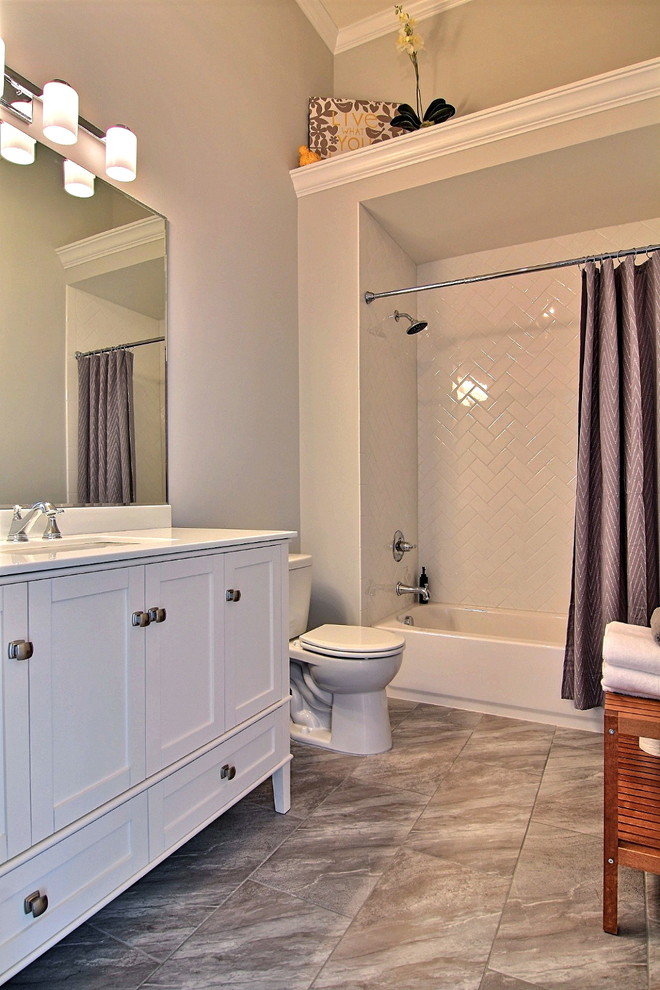 Inredning av ett modernt mellanstort vit vitt badrum med dusch, med skåp i shakerstil, vita skåp, ett badkar i en alkov, en dusch/badkar-kombination, en toalettstol med separat cisternkåpa, keramikplattor, grå väggar, kalkstensgolv, ett undermonterad handfat, bänkskiva i akrylsten, grått golv och dusch med duschdraperi