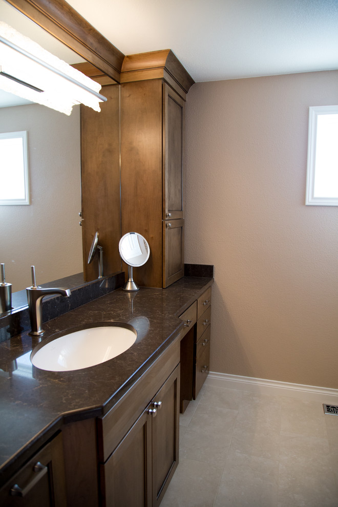Inspiration for a large classic ensuite bathroom in Denver with flat-panel cabinets, brown cabinets, a double shower, a one-piece toilet, beige tiles, porcelain tiles, beige walls, porcelain flooring, a submerged sink and engineered stone worktops.