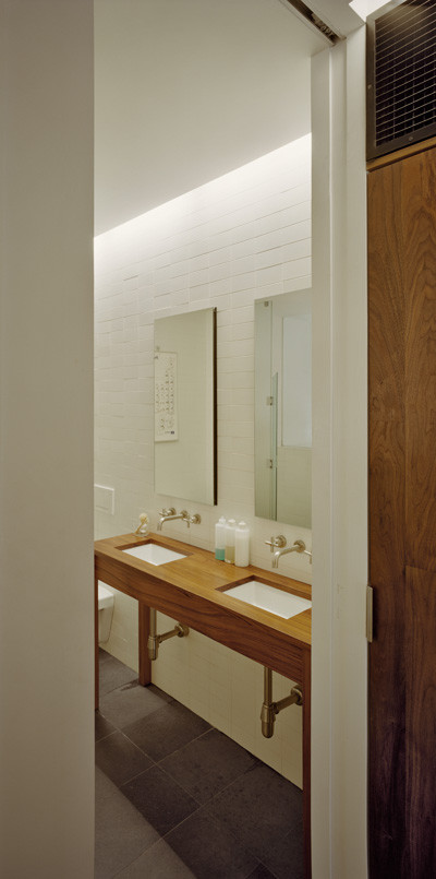 Mid-sized trendy master white tile and subway tile slate floor bathroom photo in New York with wood countertops, a wall-mount toilet, white walls and an undermount sink