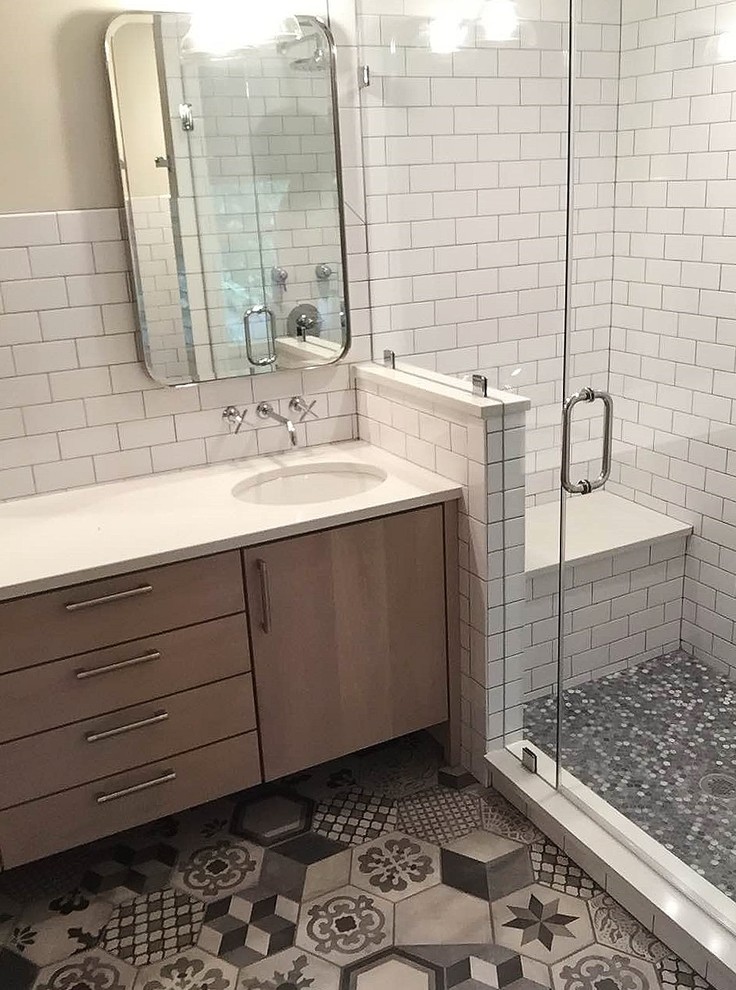 Inspiration for a large eclectic black and white tile and porcelain tile porcelain tile corner shower remodel in Philadelphia with medium tone wood cabinets, an undermount sink and quartz countertops