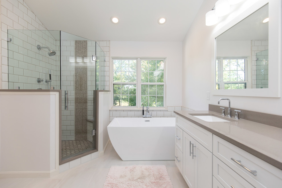 Example of a mid-sized transitional master white tile and subway tile porcelain tile and white floor bathroom design in DC Metro with shaker cabinets, white cabinets, white walls, an undermount sink, solid surface countertops and a hinged shower door