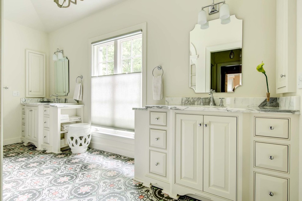Inredning av ett klassiskt litet en-suite badrum, med ett undermonterad handfat, luckor med profilerade fronter, vita skåp, marmorbänkskiva, ett fristående badkar, en öppen dusch, vita väggar och mosaikgolv
