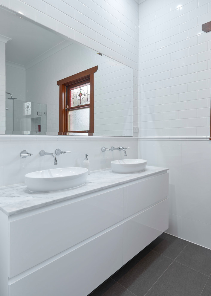 Small classic ensuite bathroom in Other with flat-panel cabinets, white cabinets, a freestanding bath, a corner shower, white tiles, porcelain tiles, white walls, porcelain flooring, a vessel sink, marble worktops, grey floors, a hinged door and multi-coloured worktops.