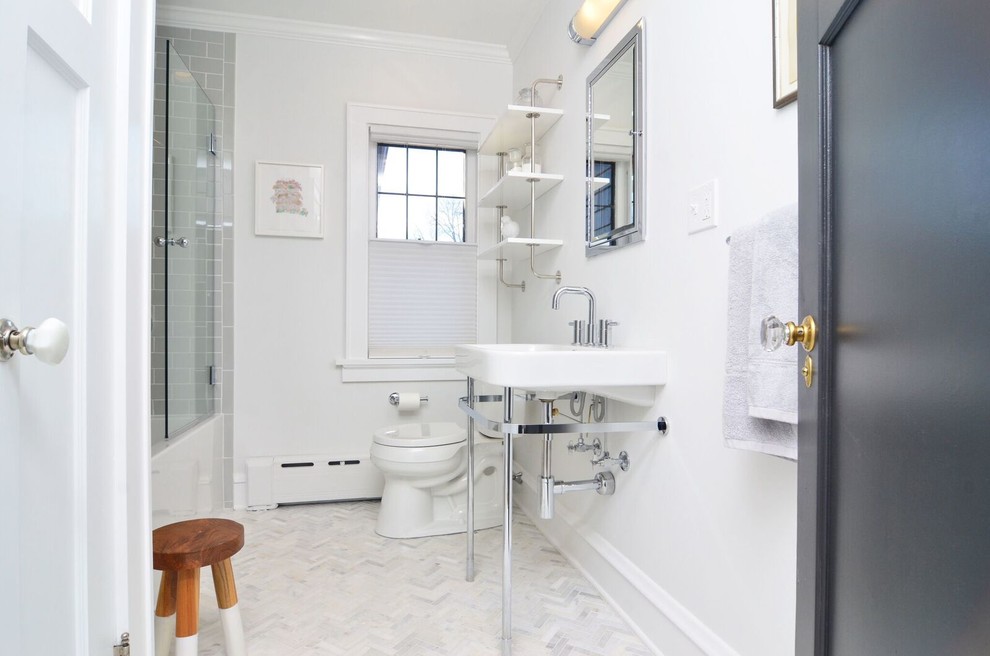 Ispirazione per una stanza da bagno tradizionale di medie dimensioni con vasca da incasso, WC a due pezzi, piastrelle in pietra, pareti grigie, pavimento in marmo e lavabo a consolle