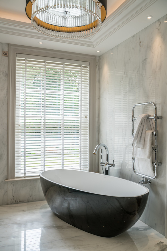 Стильный дизайн: главная ванная комната в современном стиле с отдельно стоящей ванной, серой плиткой, плиткой из листового камня, серыми стенами, серым полом и окном - последний тренд