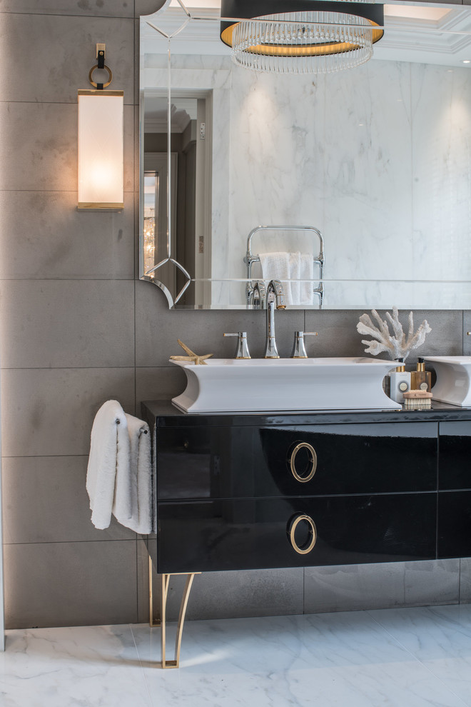 Idée de décoration pour une salle de bain design avec des portes de placard noires, un carrelage gris, un mur gris, une vasque, un sol blanc, un plan de toilette noir et un placard à porte plane.