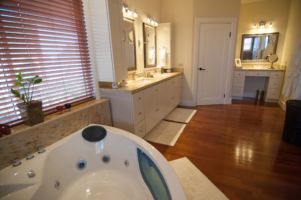Стильный дизайн: ванная комната среднего размера в классическом стиле с фасадами с выступающей филенкой, фасадами цвета дерева среднего тона, столешницей из гранита, желтыми стенами и темным паркетным полом - последний тренд