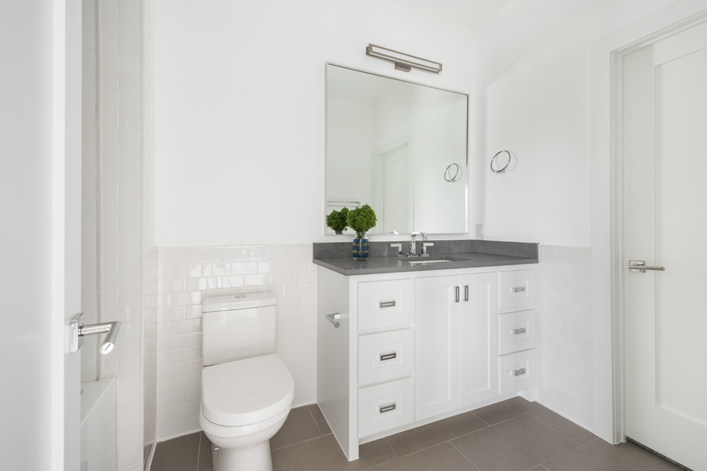 Example of a mid-sized trendy 3/4 white tile and subway tile ceramic tile and gray floor bathroom design in Dallas with shaker cabinets, white cabinets, a two-piece toilet, white walls, an undermount sink, quartz countertops and gray countertops